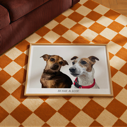 A framed Bordered Cartoon Pet Portrait of two dogs, named BESSIE & IZZIE, placed on an orange and cream checkered rug next to a brown striped sofa.