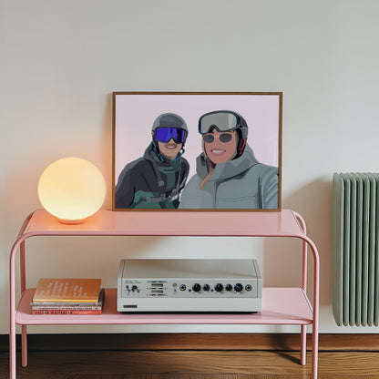Pink console table with a lamp, books, and a vintage radio against a white wall with a framed Faceless Portrait of two people in skiing gear.