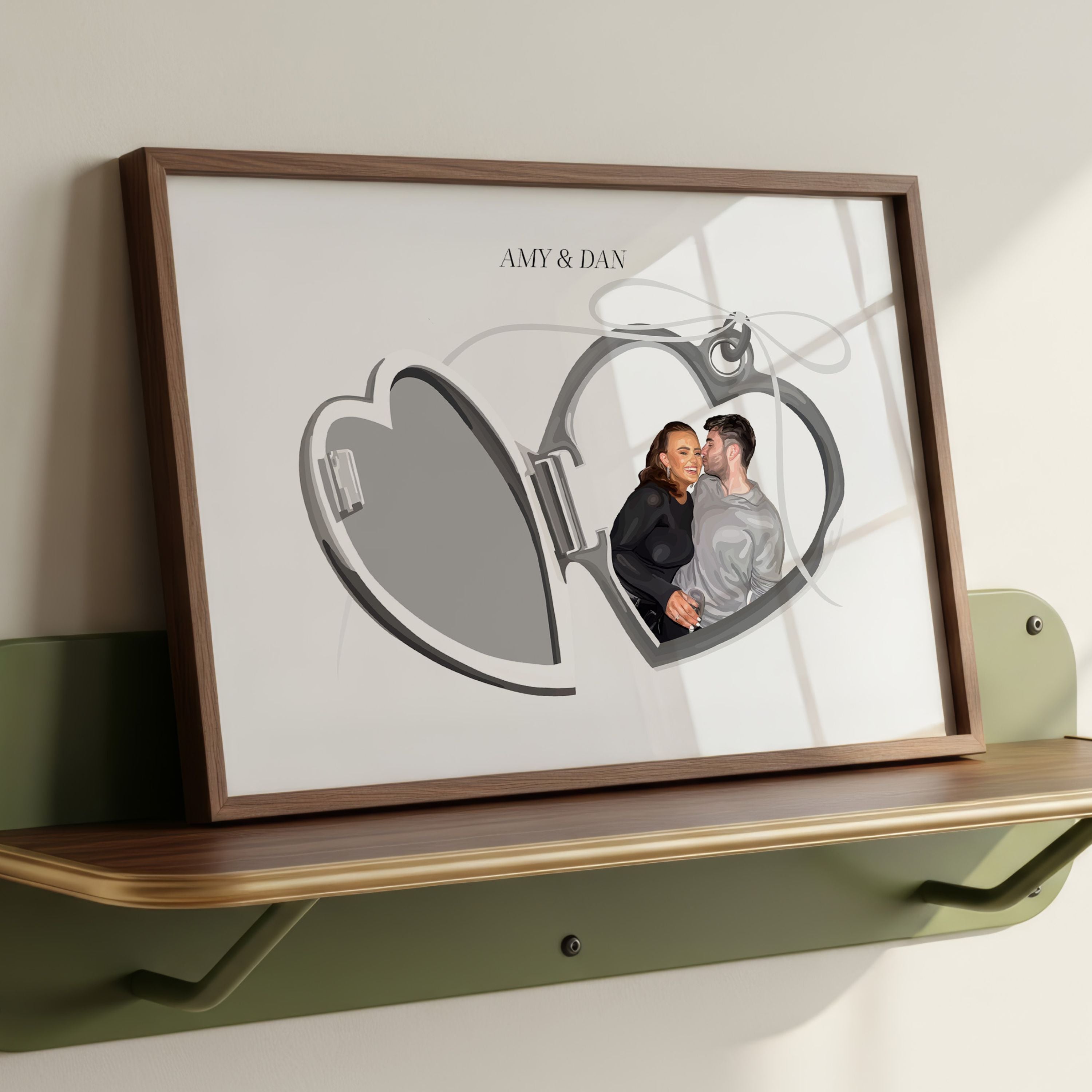Locket Portrait of a couple Amy and Dan in a wooden frame resting on a green shelf.