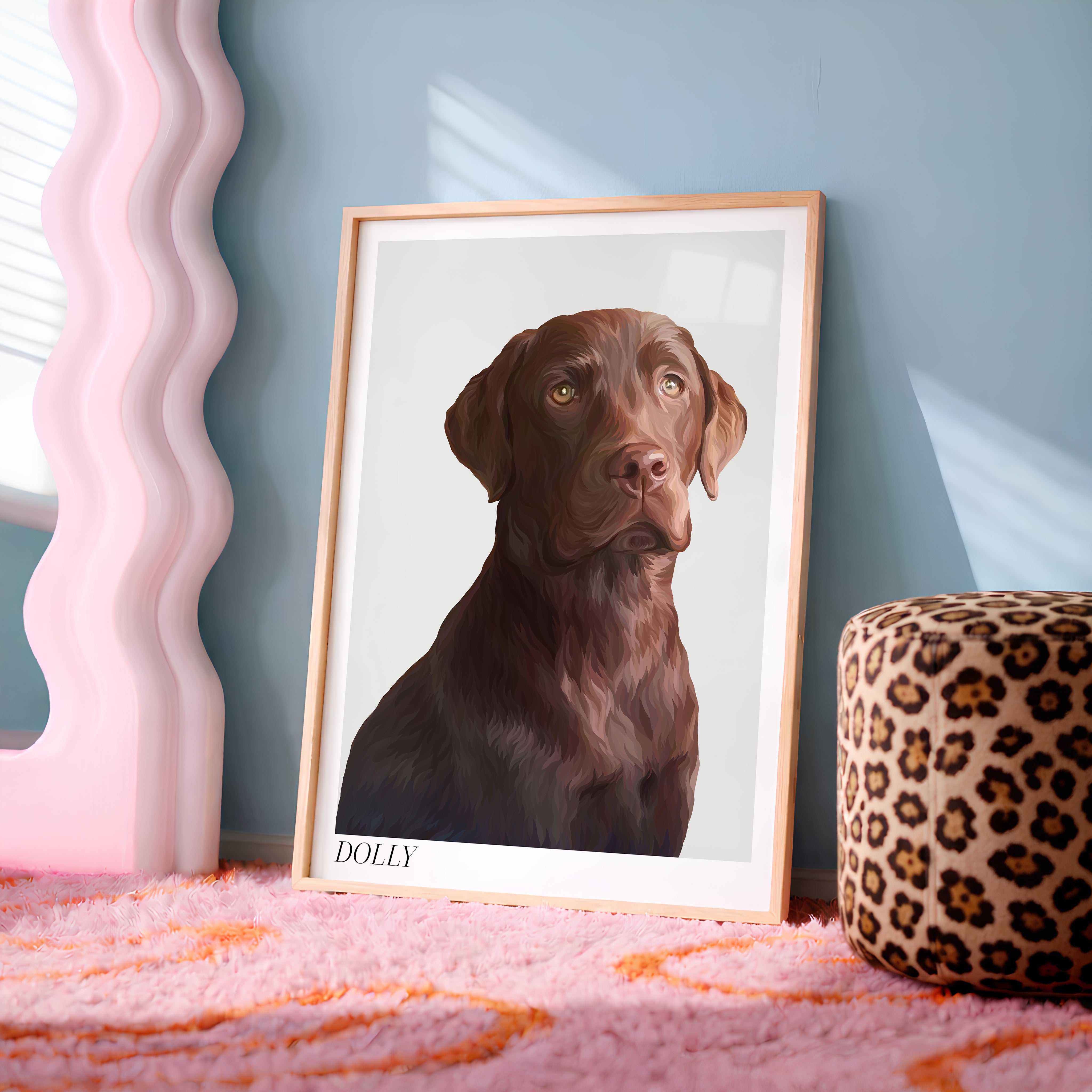 A framed custom Bordered Detailed Pet Portrait of brown Labrador leaning against a blue-grey wall on a pink rug, next to a pink wavy mirror and a leopard print ottoman.