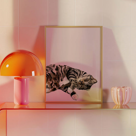A Cartoon Pet Portrait of a sleeping black and white cat displayed in a gold frame, with a tiled background, placed on a shelf alongside a pink vase and an orange lamp.