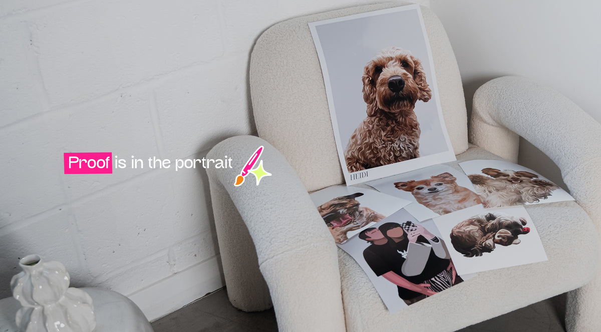 A cream-coloured armchair in a bright room, styled with several printed portraits of dogs and people. A pink text overlay on the left reads 'Proof is in the portrait' with a small pink pencil graphic.