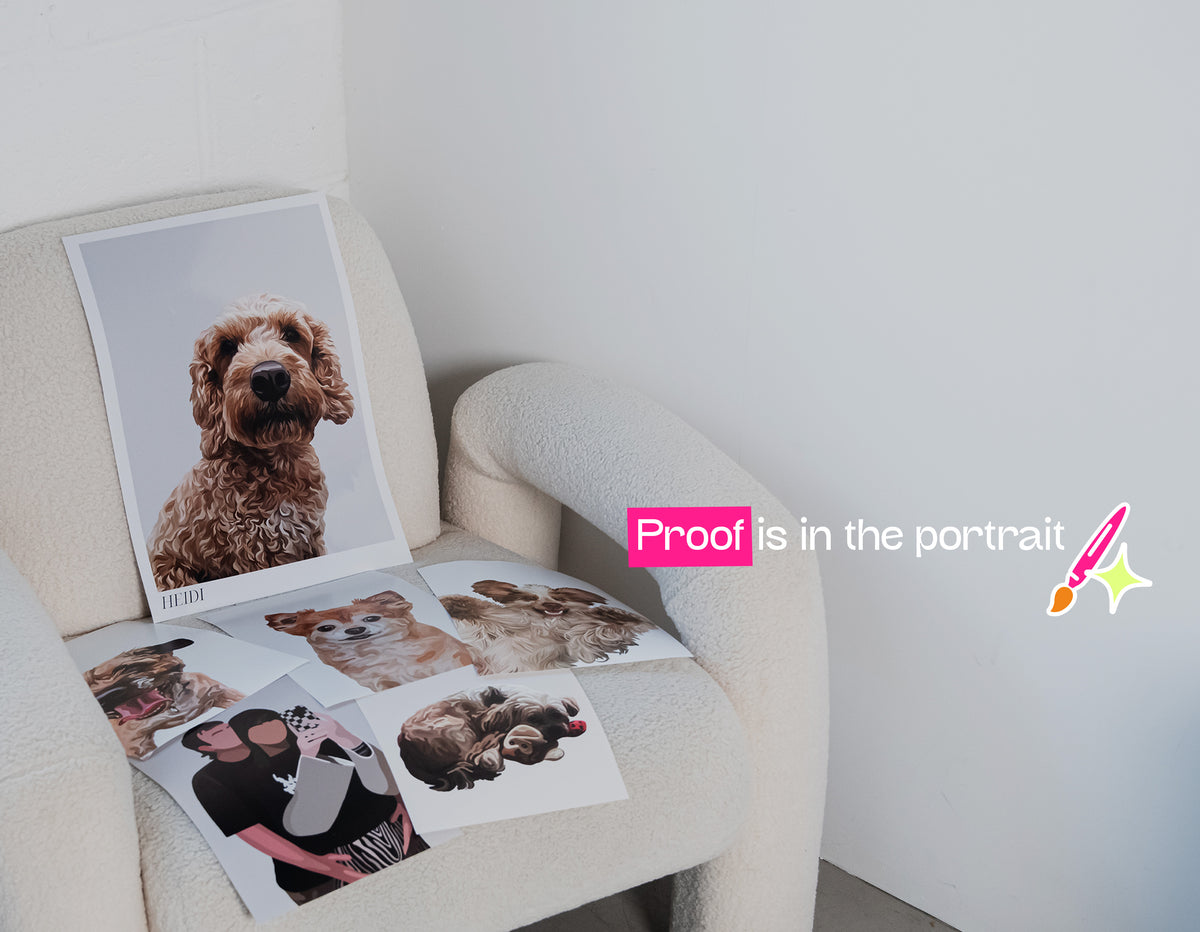 A cream-coloured armchair in a bright room, styled with several printed portraits of dogs and people. A pink text overlay on the left reads 'Proof is in the portrait' with a small pink pencil graphic.