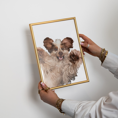 Detailed Pet Portrait of a fluffy, beige and brown dog with its paws up in the air. The print is in a gold frame being held against a white wall.