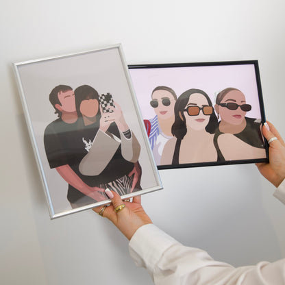 Two framed Faceless Portraits being held up against a white wall.