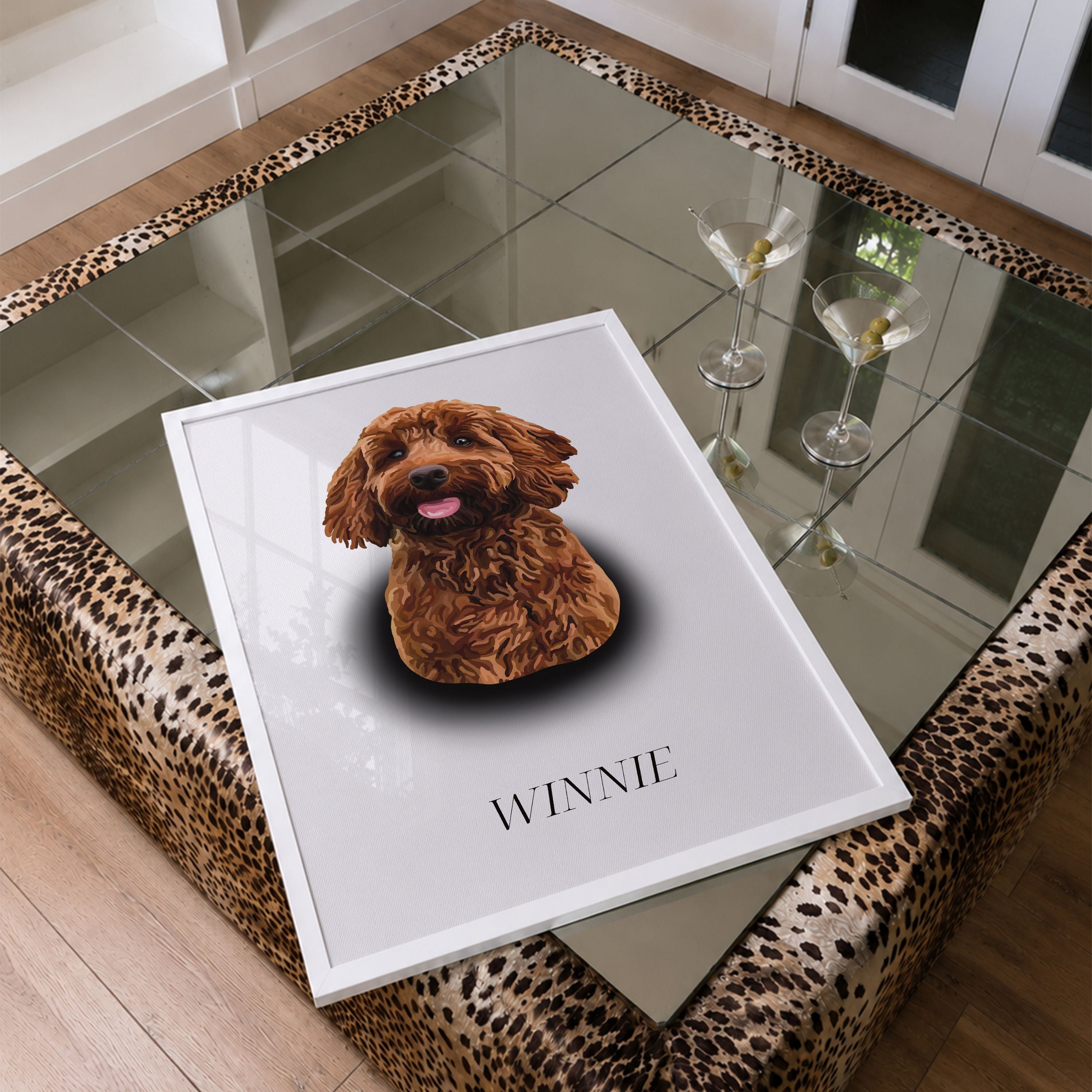 A framed Spotlight Portrait featuring a brown Cockapoo with the name 'WINNIE' printed below, displayed on a leopard-print upholstered coffee table with a mirrored glass top.